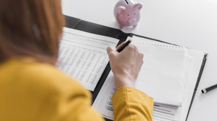 Persona revisando documentos y calculando números para entender qué significa la tasa de interés y cómo influye en su préstamo.